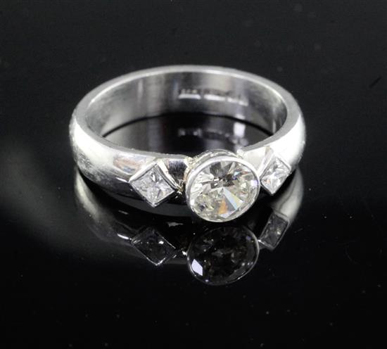 A modern platinum and single stone diamond dress ring with princess cut diamond set shoulders, size O.